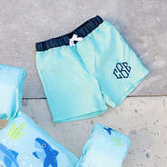 mint monogrammed kids swim trunks at pool