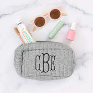 spill shot of gray quilted cosmetic case